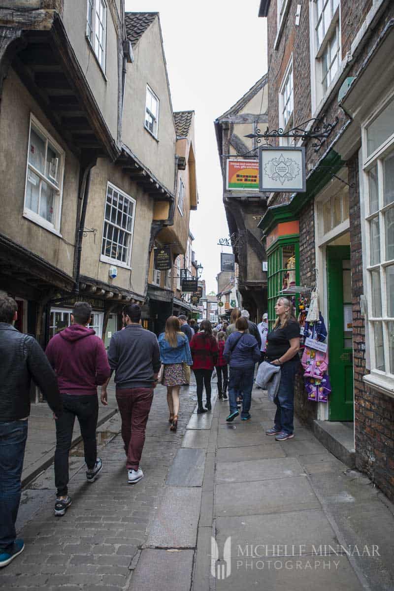 People walking down a narrow street 