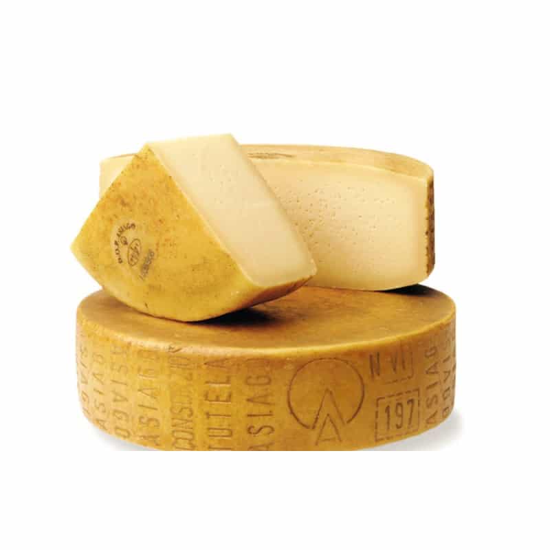 A large wheel of asiago cheese and two chuncks as a manchego cheese substitutes