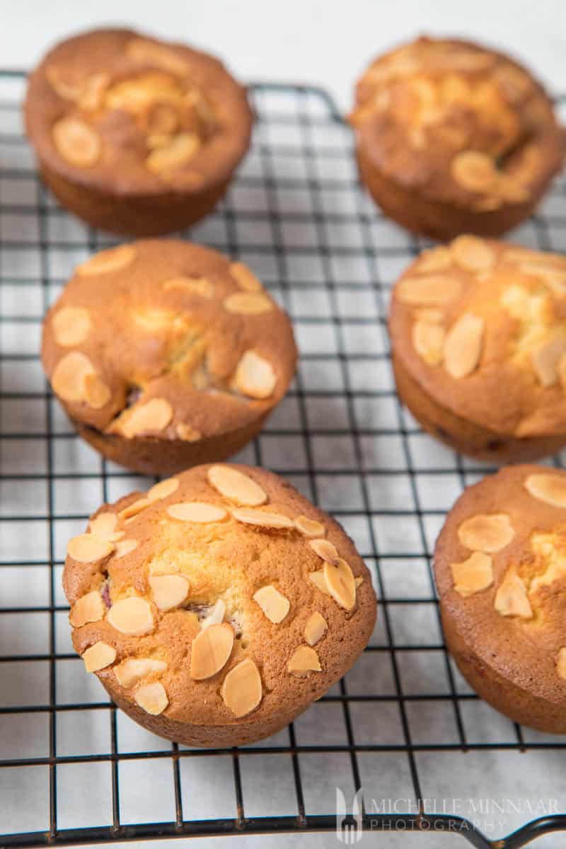 A close up of cherry muffins baked on a wire rack 