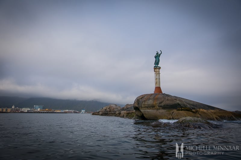 A lighthouse and statue on the coast of Norway 