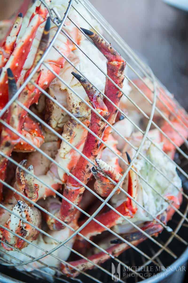 A close up view of red crab legs in a basket after steaming 