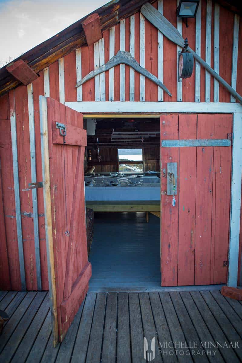 A red bar with the door open showing the tables where the people were to eat 