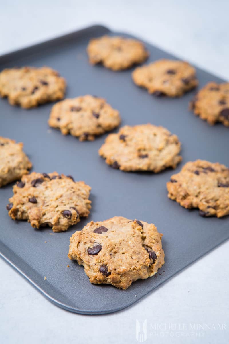 A close up of sugar free chocolate chip cookies on a sheet pan 