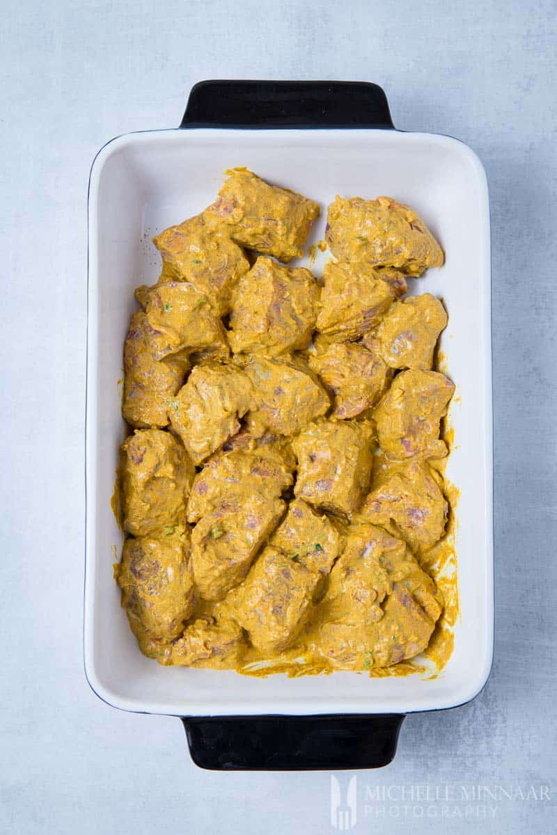 Lams Tikka Marineren in een gele saus