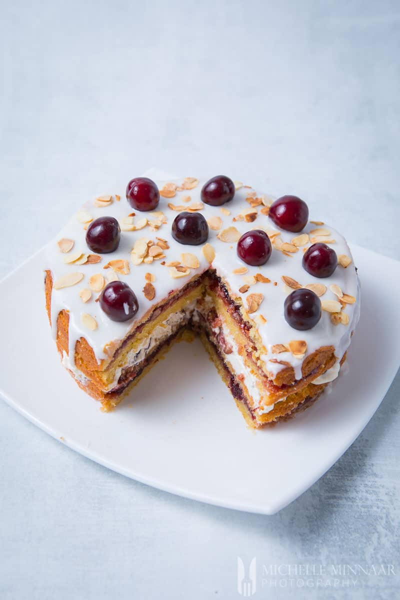 A slice cut out of the cherry bakewell cake