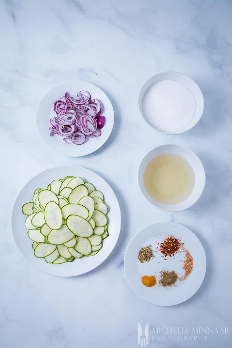 Prepared ingredients for Courgette Pickle: Sliced Onion Spices, Sliced Zucchini 