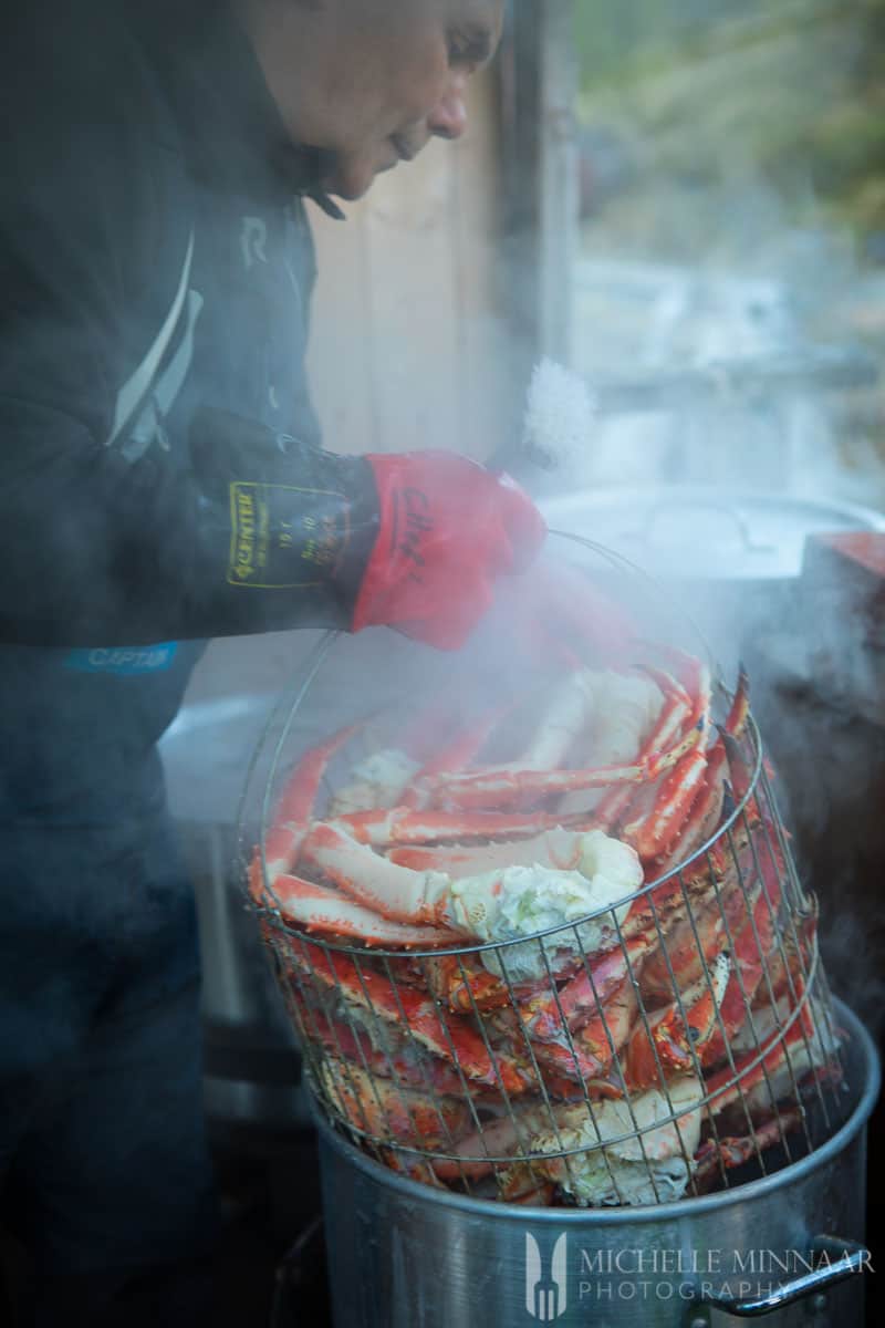 A man holding a basket of crabs about to be steamed on the King Crab Safari 