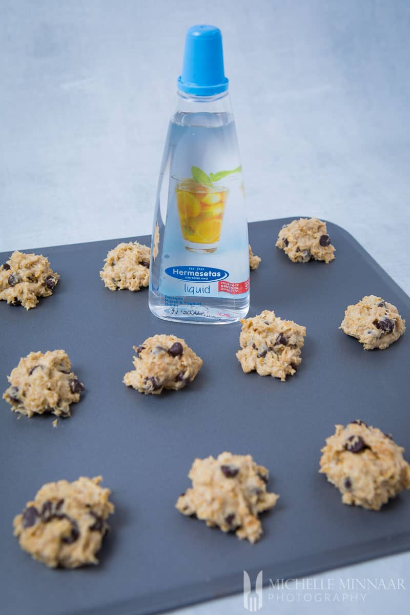 A bottle of Hermsetas clear liquid on a baking pan 