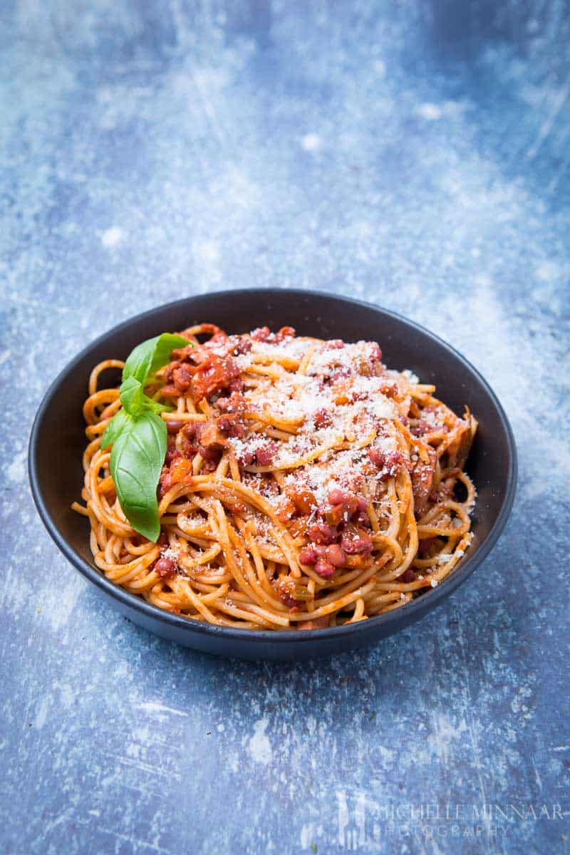 A bowl of vegan spaghetti bolognese, spaghetti with a red sauce and beans