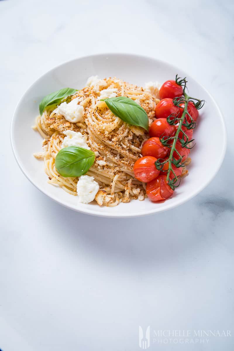 A plate of Pangritata - pasta with basil and tomatoes 