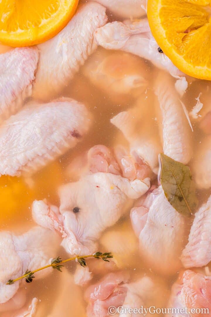 Chicken in brine with orange slices.