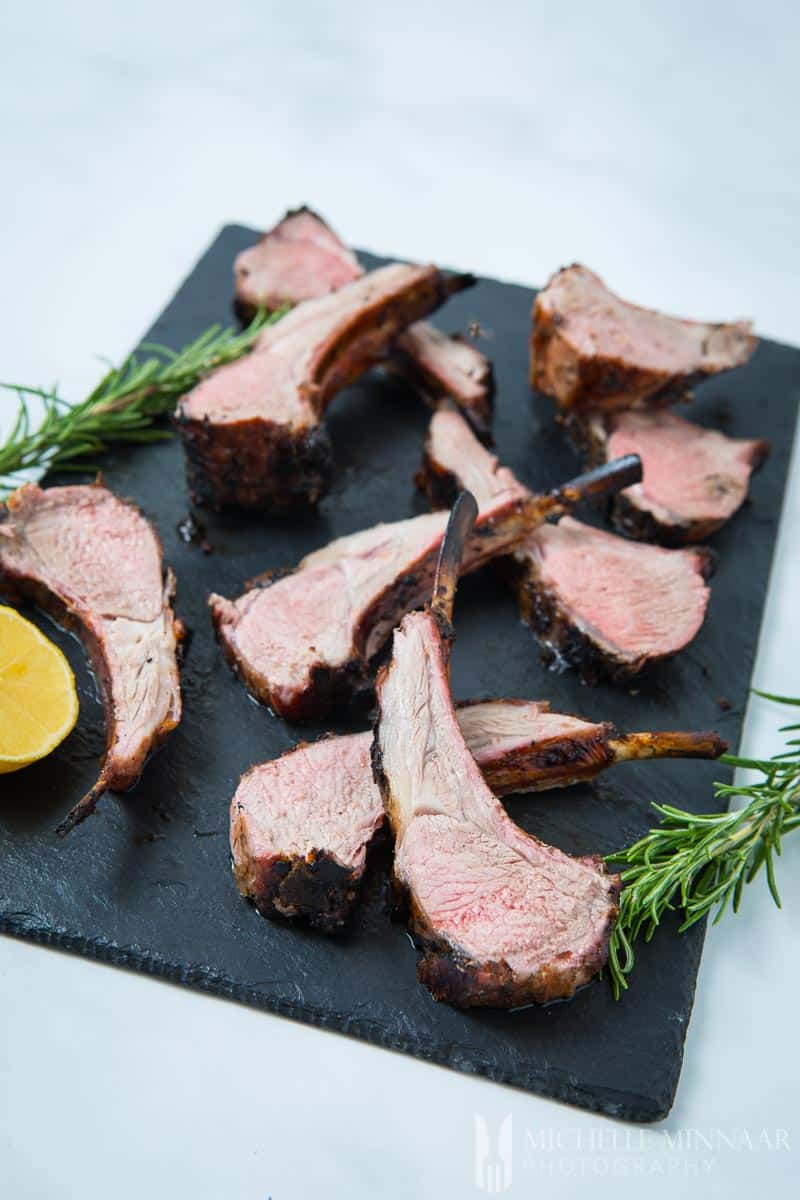 Lamb Chops on a marble slab with a lemon 