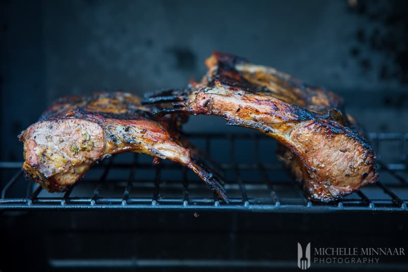 bbq rack of lamb on a wire rack inside the oven 