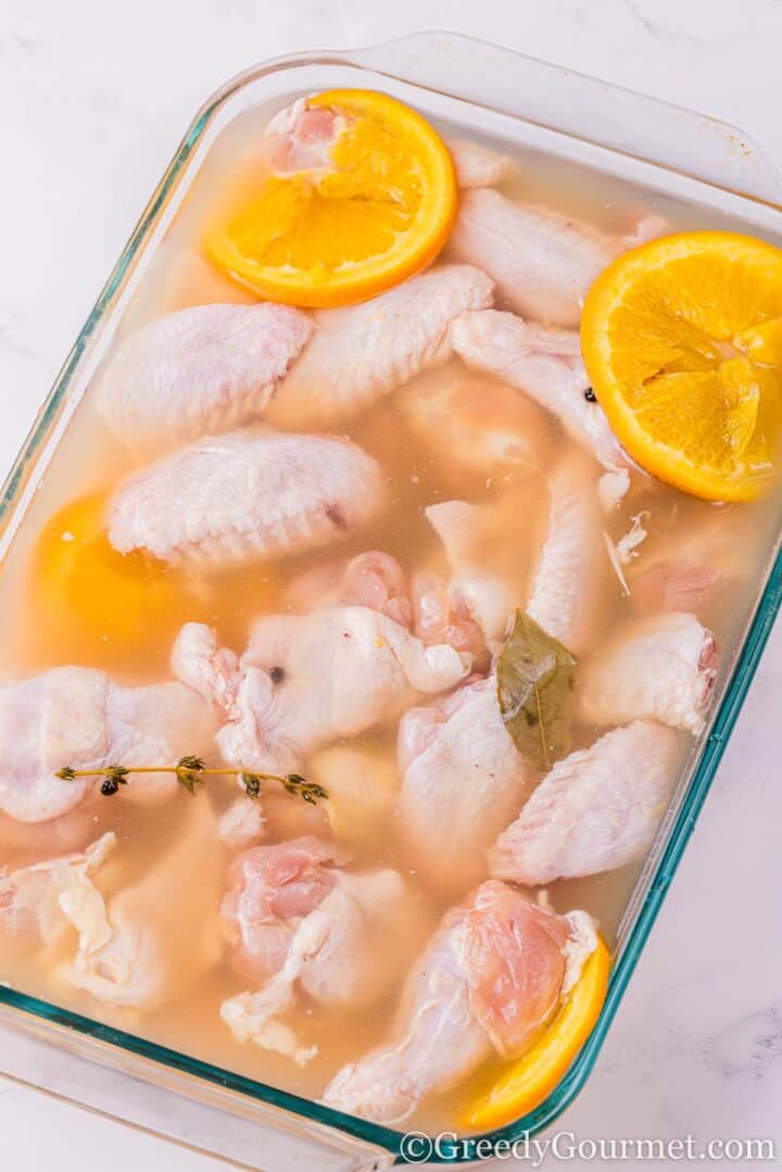 Chicken in brine with orange slices.