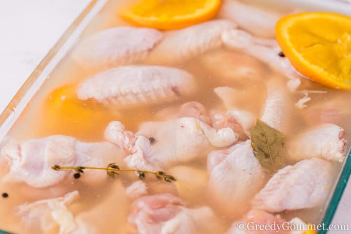 Chicken in brine with orange slices.