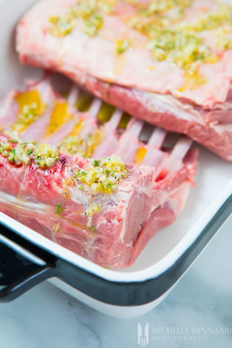 A close up of raw lack of lamb with a rosemary mixture on top 