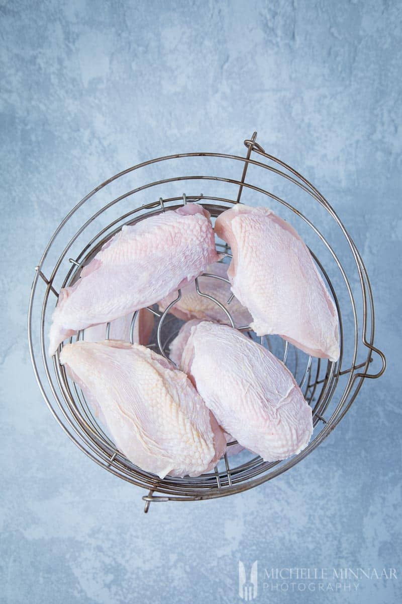 Metal basket with Raw Chicken Breast