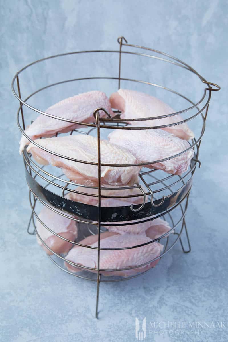 Raw Chicken Breasts in a metal basket