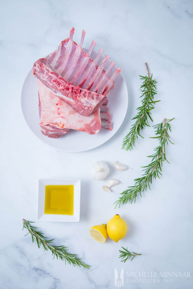 Ingredients for bbq rack of lamb: Oil Garlic Lemon, rosemary and raw rack of lamb