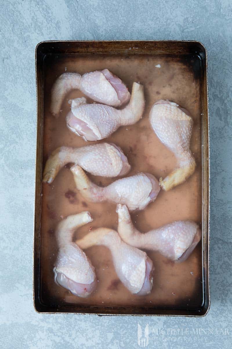 Raw Chicken Drumsticks in a brining liquid 