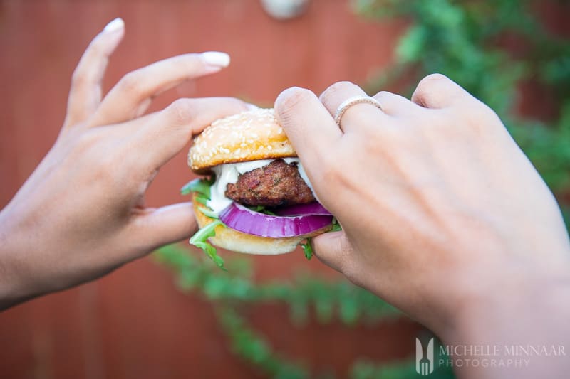 Two hands holding a burger 