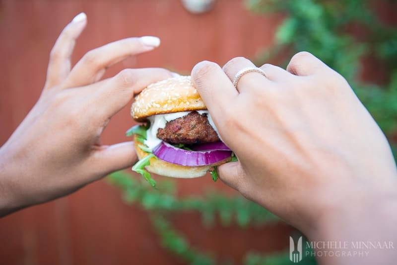 Two hands holding a burger