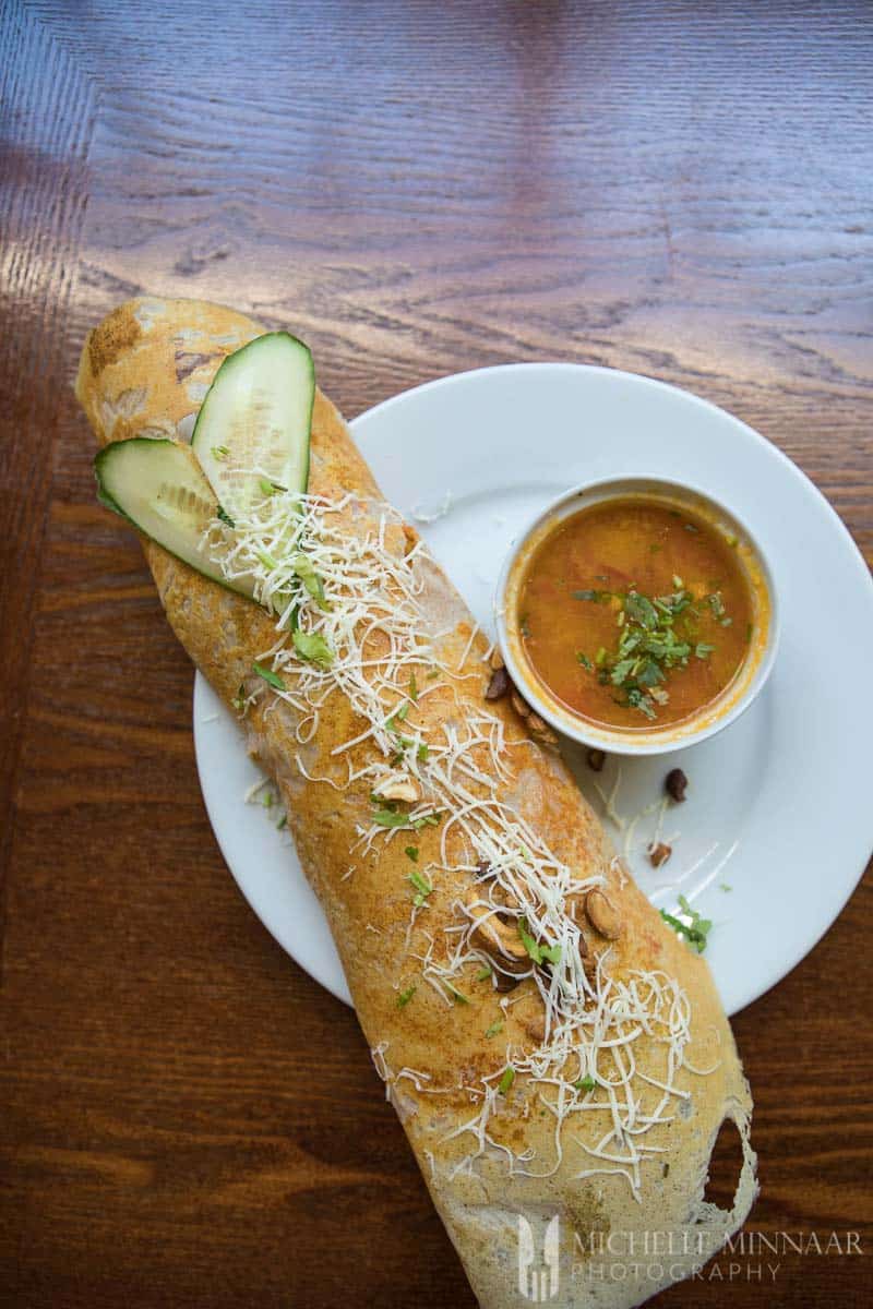 Masala Dosa - paneer with cucumbers and cheese on it 