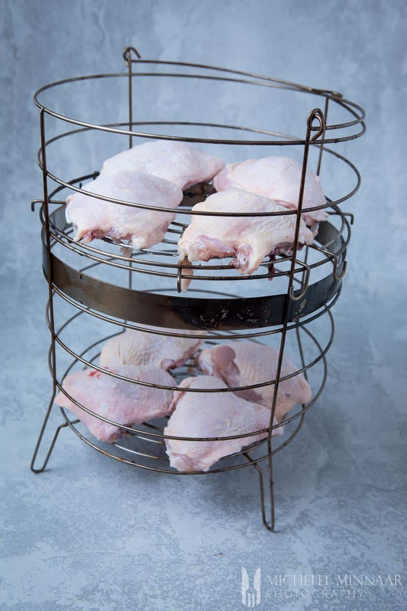 Raw chicken in a wire smoking basket 