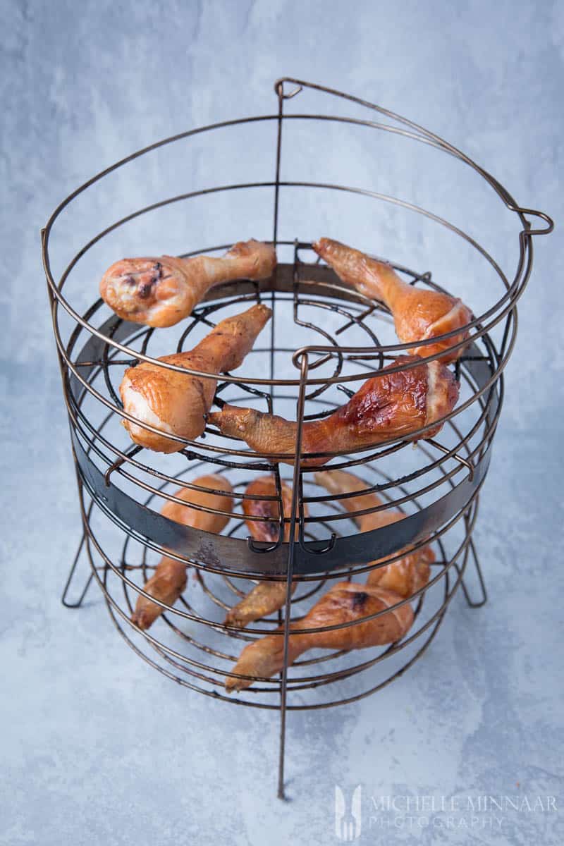 Smoked chicken drumsticks in a wire basket