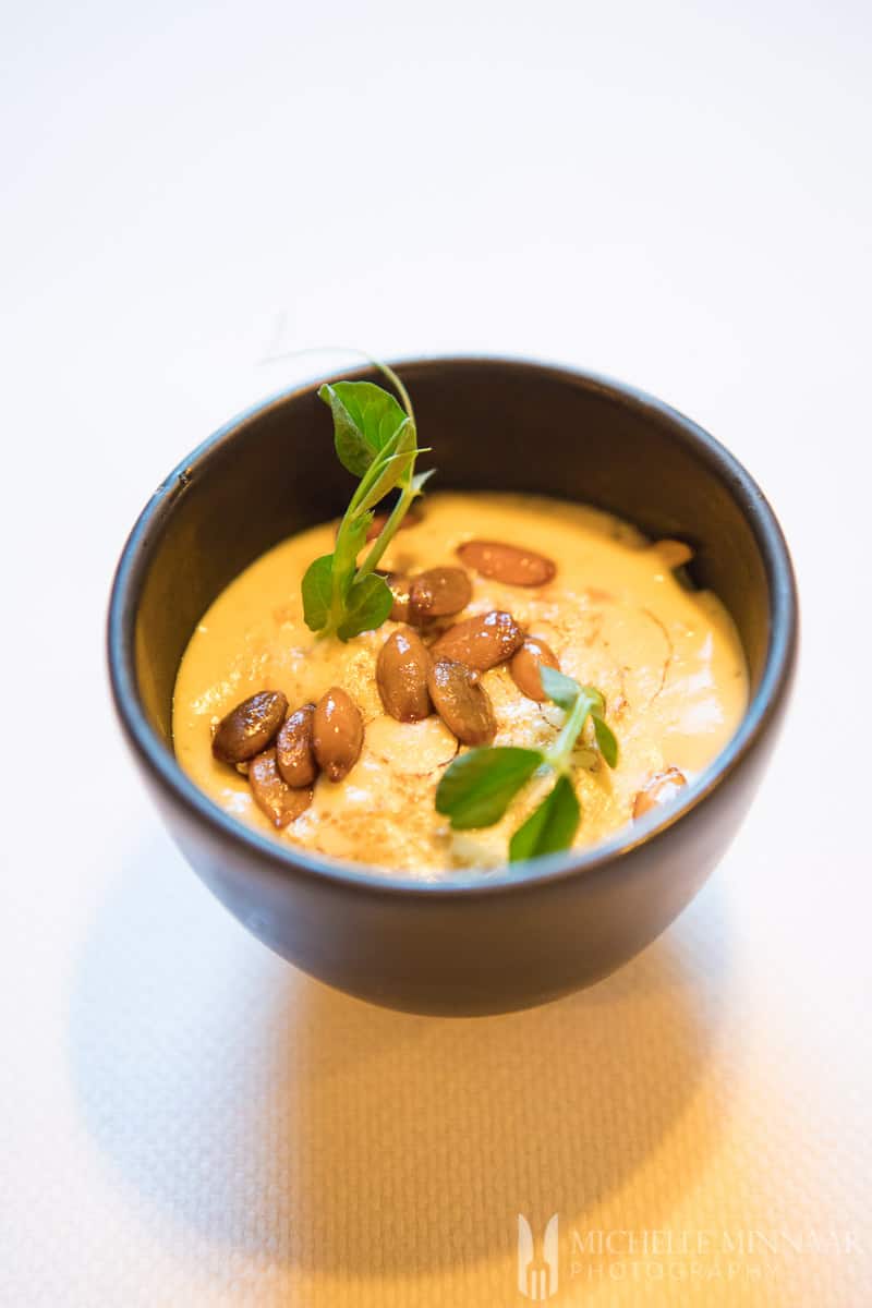 A starter at onder de linden, a small bowl of orange cream with seeds