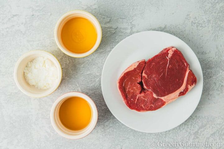 Beef, wine, corn starch and sesame oil in small dishes.