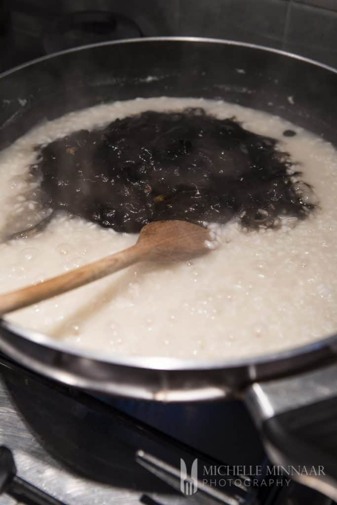 a pan of white sauce with black beans 