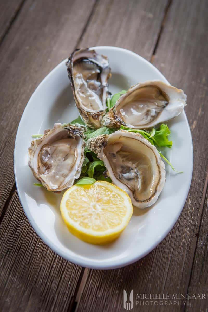 A close up of Four fresh Oysters and a lemon