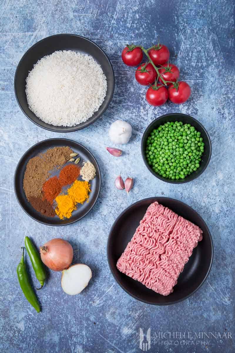 Ingredients to make Keema Rice: Ground beef, spices, peas, tomatoes, white rice 