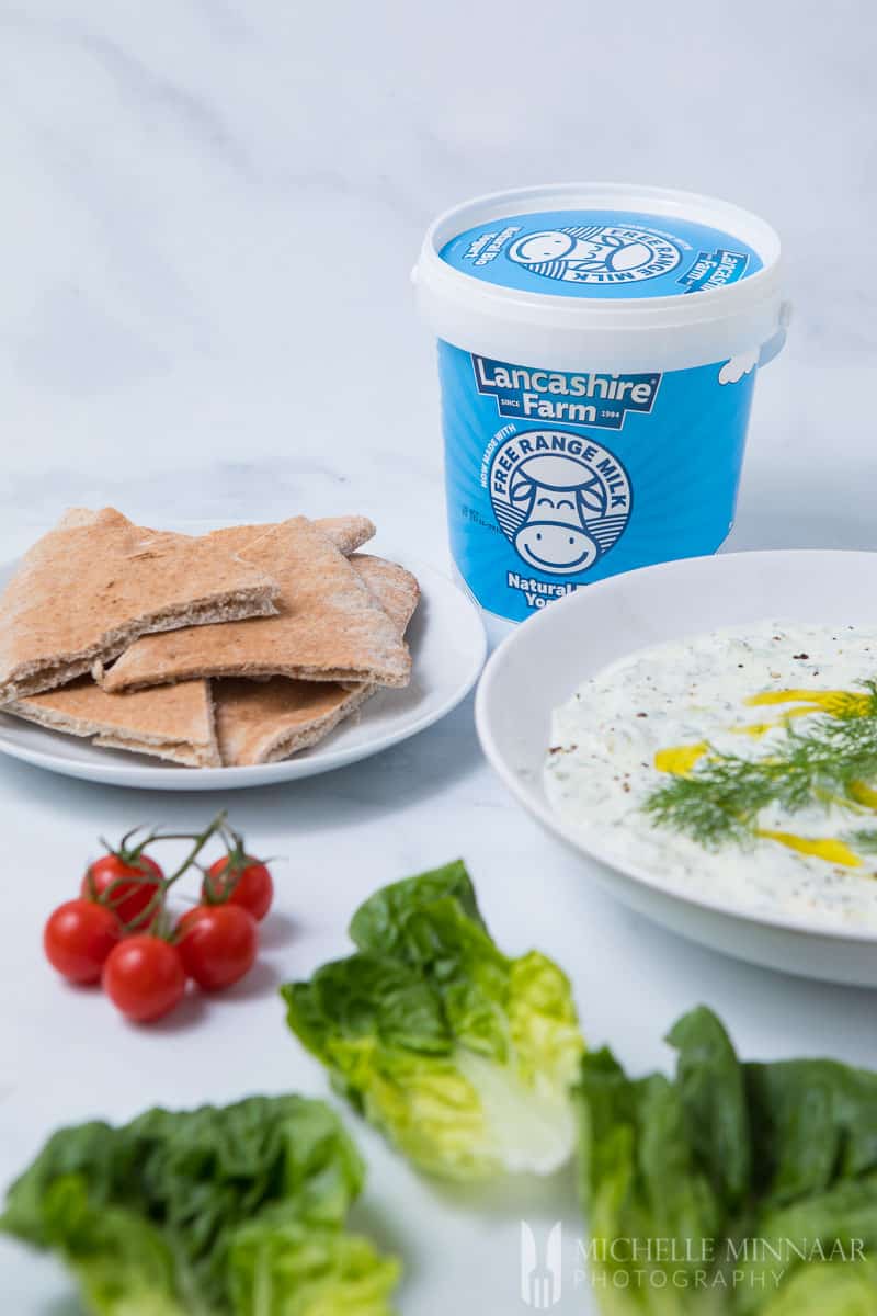 Pita bread, yogurt and cacik on a counter 