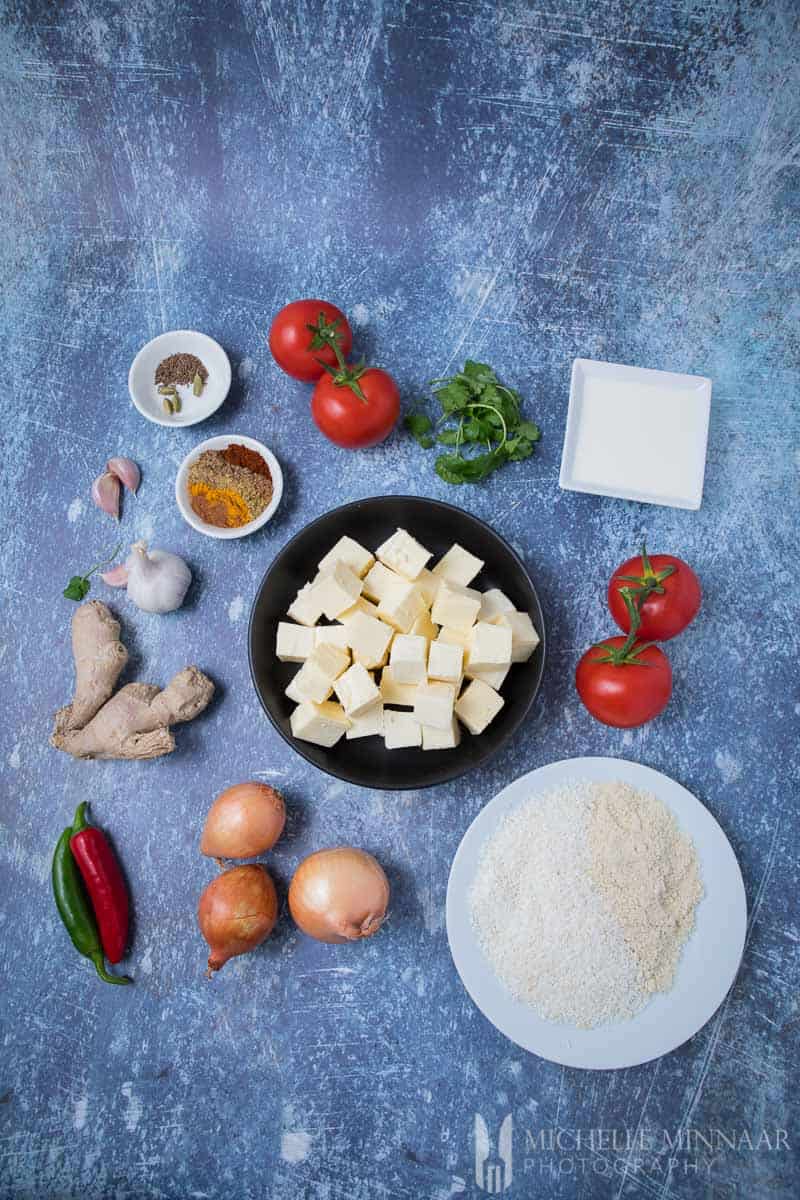 Ingredients for paneer korma: Cheese, spices, onions, tomato, Coconut, Almond, and Spices