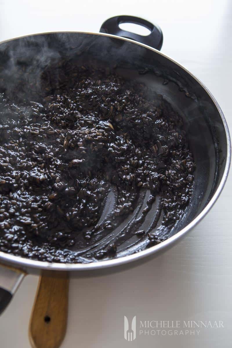 Black Risotto in cooking pan.