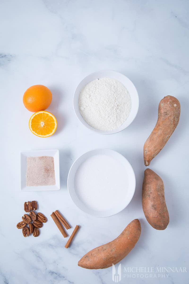 Ingredients to make vegan sweet potato pancakes " orange, flour, sugar, sweet potatoes