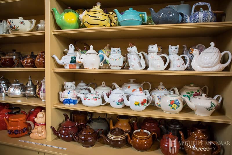 A wall of teapots in different shapes and sizes