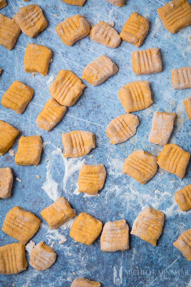 A close of of raw vegan sweet potato gnocchi cut into sqaures