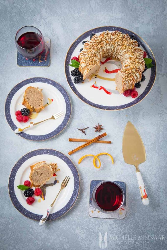 Glasses of wine with pieces of cinnamon bundt cake on plates 