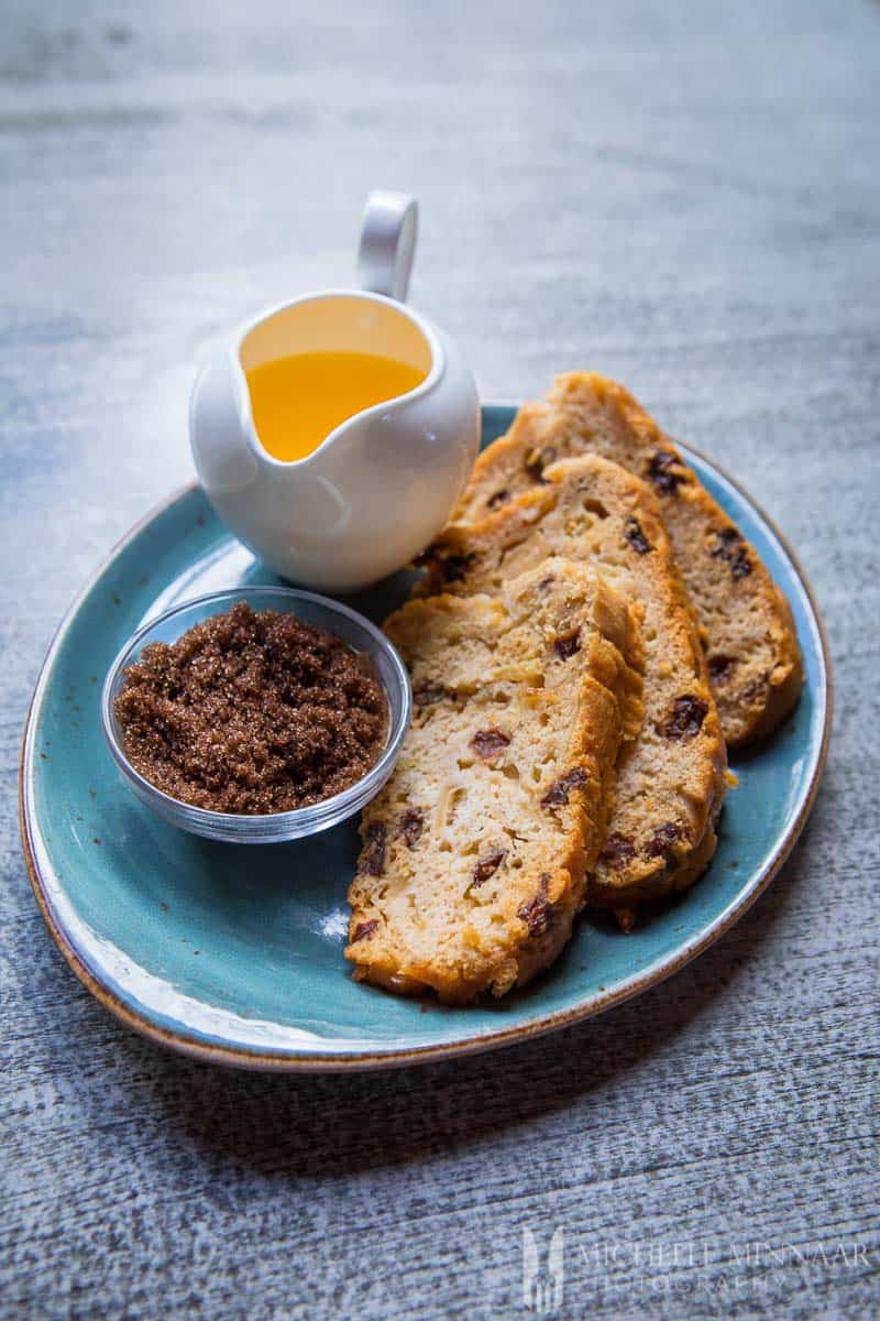 Three pieces of Poffert with some butter and sugar