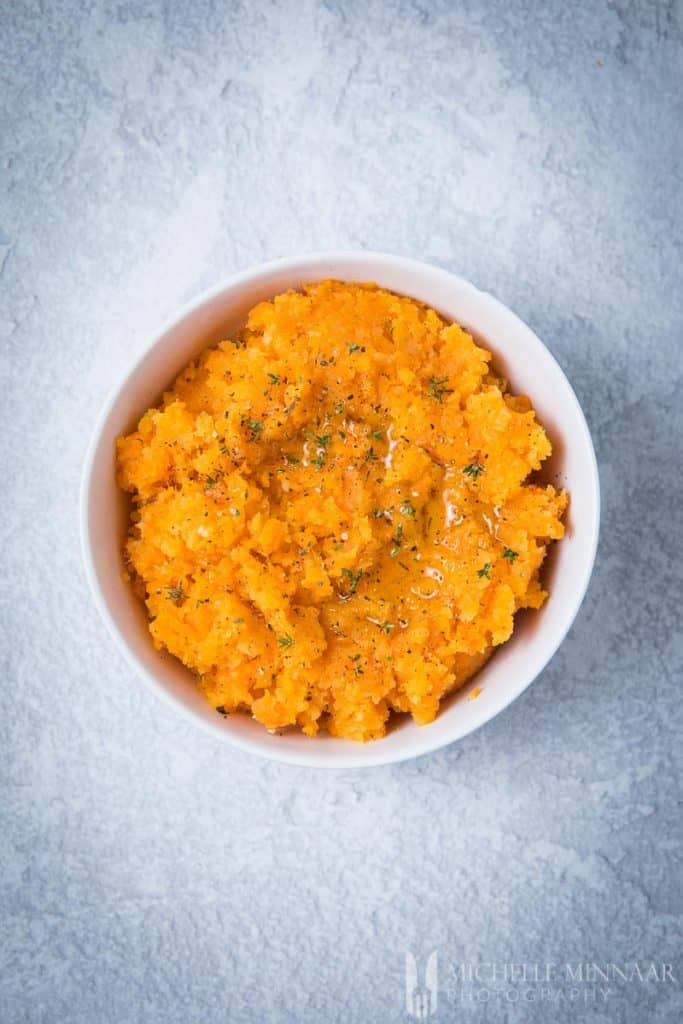 An orange bowl of carrot and swede mash