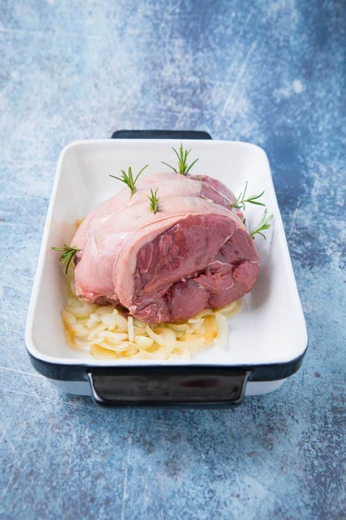 A raw chunk of venison with rosemary 