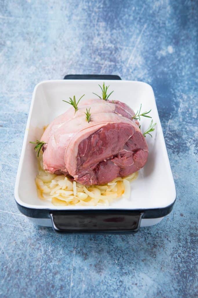 A raw chunk of venison with rosemary