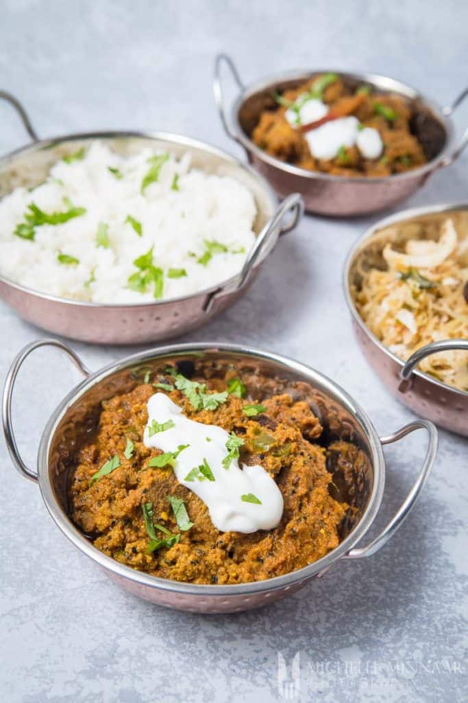 A close up of achar gosht, shredded beef with sour cream on top 