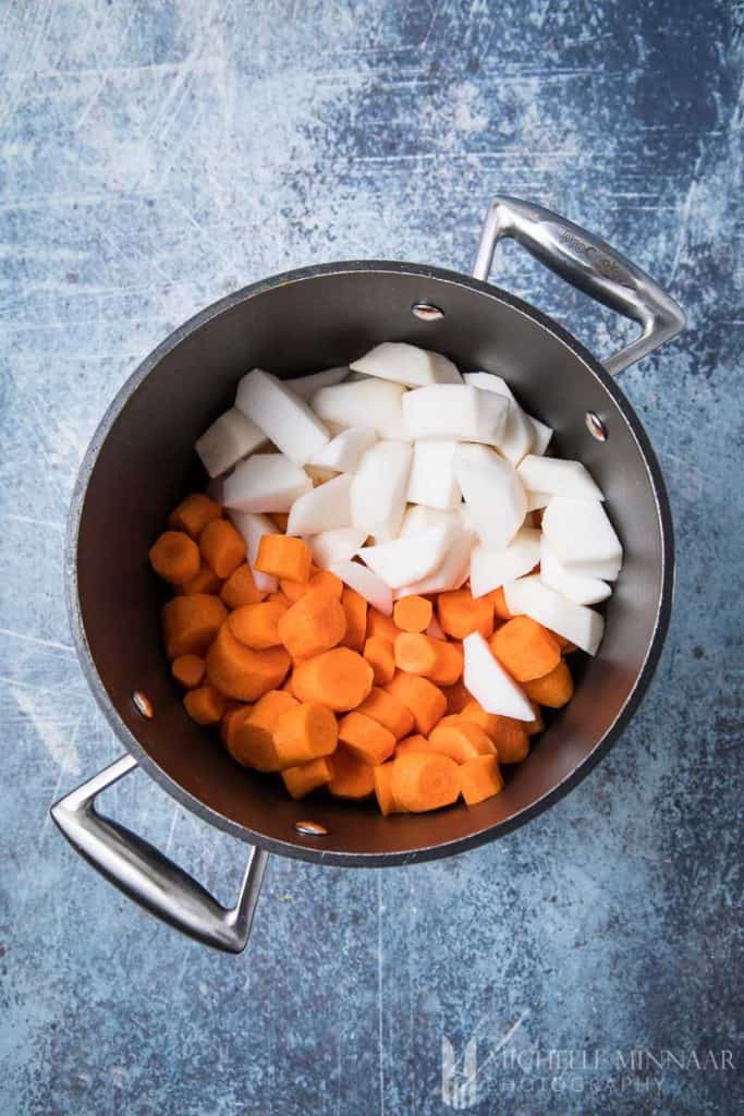 Raw carrots and turnips in a pan
