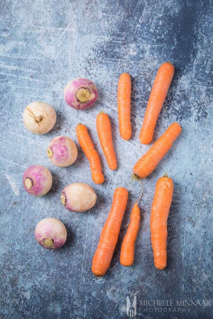 Raw turnips and carrots on a counter