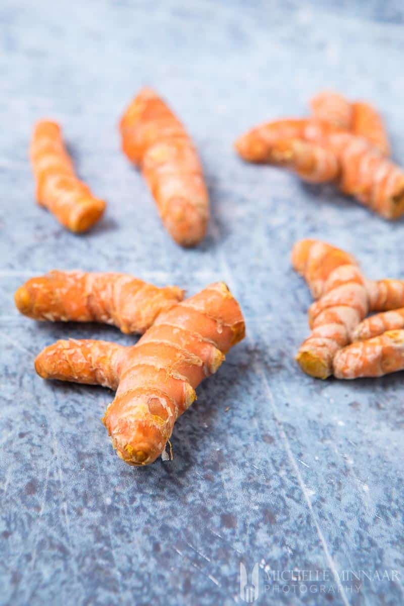 A close up of raw pieces of orange turmeric