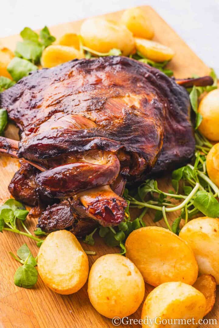 slow roast lamb shoulder served with potatoes and greens.